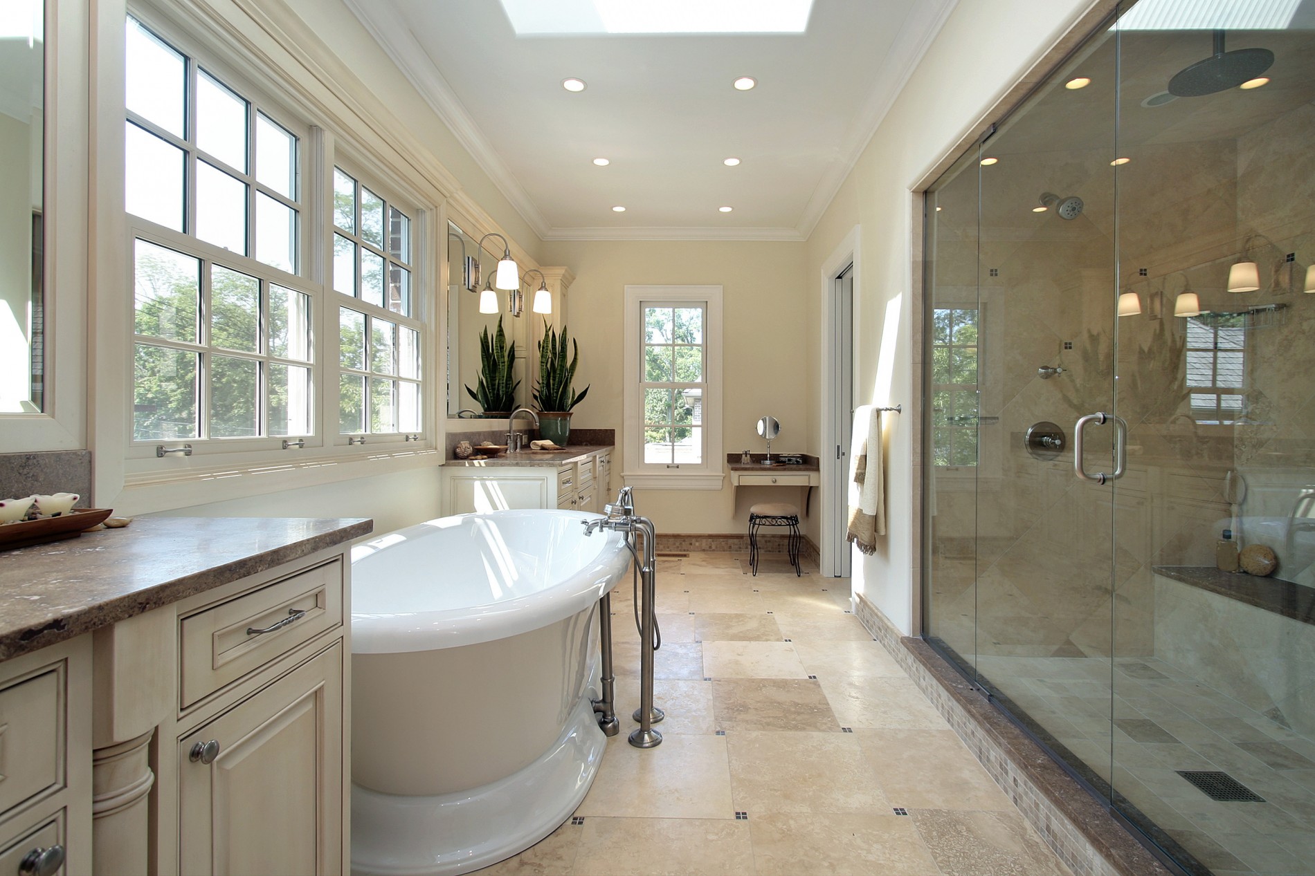 Completed Bath & Home bathroom renovation with a freestanding tub, large glass shower, and skylights