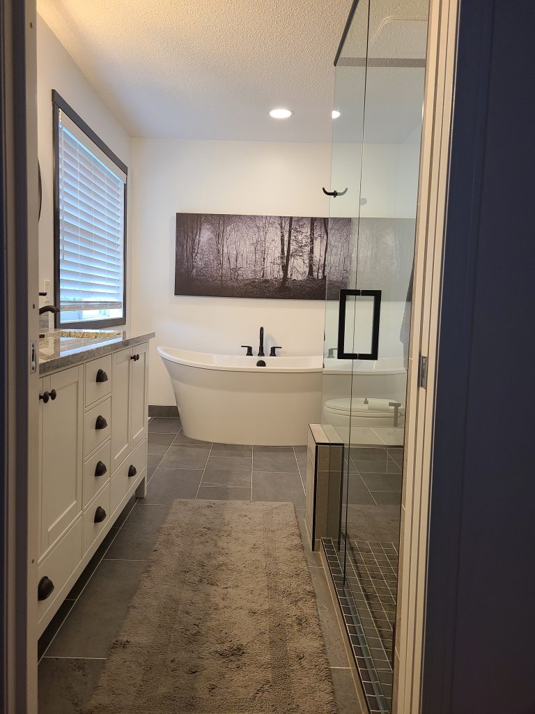 After: freestanding tub, glass shower, and double vanity