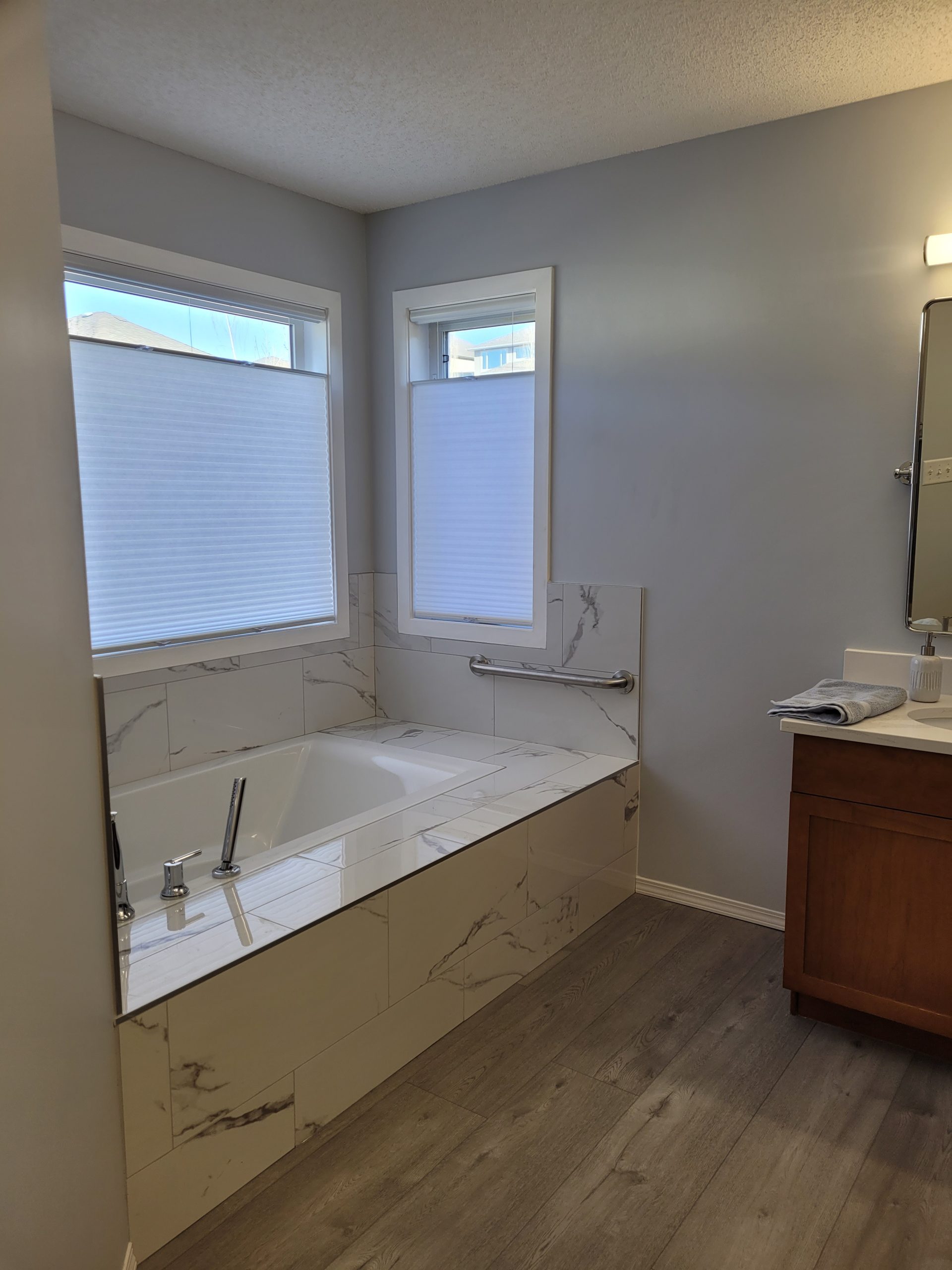 Bathroom with tub and wood vanity